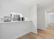 Thumbnail 92 of 92 - A kitchen with white cabinets and a wooden floor.