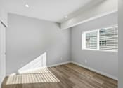 Thumbnail 54 of 67 - A room with a white door, a window with blinds, and a wooden floor.
