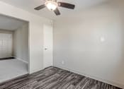 Thumbnail 46 of 51 - A room with a ceiling fan and wood flooring.