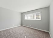 Thumbnail 23 of 33 - A room with a window and carpeted floor.