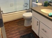 Thumbnail 31 of 43 - A white toilet sits in a bathroom next to a sink.