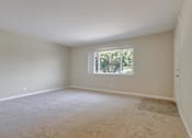 Thumbnail 23 of 34 - A room with a window and carpeted floor.