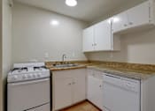 Thumbnail 14 of 38 - A kitchen with white appliances and cabinets.