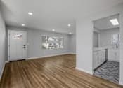 Thumbnail 17 of 31 - A room with wooden flooring and white walls.