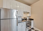 Thumbnail 39 of 42 - A kitchen with a stainless steel refrigerator, oven, and range hood.