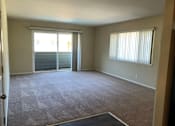 Thumbnail 8 of 22 - A room with a carpet floor and a window with blinds.