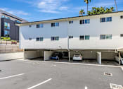 Thumbnail 38 of 43 - A white building with a parking garage in front of it.