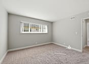 Thumbnail 15 of 33 - A room with a window and a door is empty and waiting to be furnished.