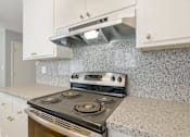 Thumbnail 15 of 29 - a kitchen with white cabinets and a stove top oven
