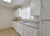 Thumbnail 20 of 37 - A kitchen with white cabinets and a granite countertop.