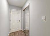 Thumbnail 23 of 27 - A white door with a gold handle is in a room with a light switch on the wall.