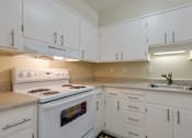 Thumbnail 13 of 33 - a kitchen with white cabinets and a stove and a sink