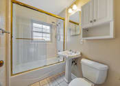 Thumbnail 17 of 21 - A white toilet sits next to a sink in a bathroom.
