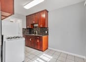 Thumbnail 31 of 38 - A kitchen with white appliances and brown cabinets.