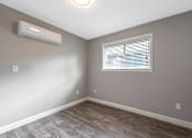 Thumbnail 57 of 62 - A room with a window and a wall-mounted air conditioner.