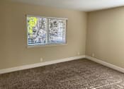 Thumbnail 21 of 43 - A room with a window covered in blinds and carpet on the floor.
