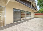 Thumbnail 5 of 33 - A house with a patio and sliding glass doors.