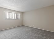 Thumbnail 27 of 51 - A room with a carpeted floor and a window with blinds.