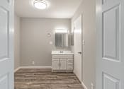 Thumbnail 41 of 42 - A bathroom with a vanity and a mirror.