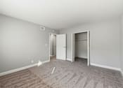 Thumbnail 19 of 33 - A room with a carpeted floor and two open doors.
