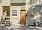 Thumbnail 11 of 36 - a yellow door on the side of a building with stairs