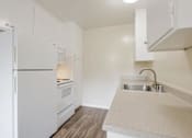Thumbnail 27 of 37 - A kitchen with a white fridge and a sink.