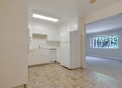 Thumbnail 18 of 34 - A kitchen with white appliances and cabinets.