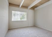 Thumbnail 26 of 32 - Empty room with a window and a wooden ceiling.