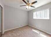 Thumbnail 22 of 27 - A room with a ceiling fan and a window with blinds.