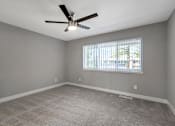 Thumbnail 24 of 53 - an empty living room with a ceiling fan and a window