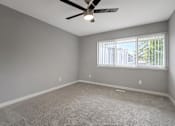Thumbnail 31 of 53 - an empty living room with a ceiling fan and a window