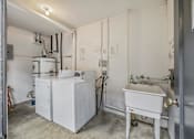 Thumbnail 18 of 21 - A white industrial machine sits in a room with a white door.