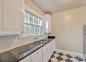 Thumbnail 40 of 42 - A kitchen with white cabinets and a black and white checkered floor.