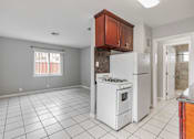 Thumbnail 32 of 38 - A kitchen with white appliances and a white tile floor.