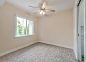 Thumbnail 20 of 29 - A room with a ceiling fan and a window with blinds.