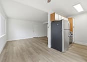 Thumbnail 55 of 63 - A kitchen with a refrigerator and wooden floors.
