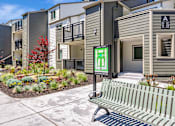 Thumbnail 15 of 41 - A bench is in front of a building with a green sign that says "A".