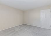 Thumbnail 23 of 51 - A room with a white door and carpeted floor.