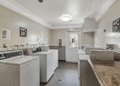 Thumbnail 33 of 40 - A laundry room with washers and dryers.