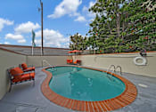 Thumbnail 10 of 16 - A small round pool with a brick border and a chair.