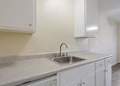 Thumbnail 28 of 37 - A kitchen with a sink and cabinets.