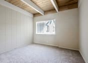 Thumbnail 27 of 32 - Empty room with white walls and a window.
