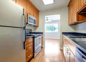 Thumbnail 21 of 37 - A kitchen with a white refrigerator and wooden cabinets.