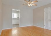 Thumbnail 31 of 37 - A room with a ceiling fan and wooden floors.