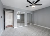 Thumbnail 23 of 53 - an empty bedroom with a ceiling fan and a mirrored closet