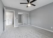 Thumbnail 30 of 53 - an empty living room with a ceiling fan and a mirrored closet