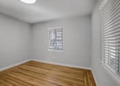 Thumbnail 18 of 31 - A room with wooden flooring and a window with blinds.