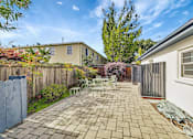 Thumbnail 1 of 21 - A backyard with a patio and a fence.