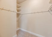 Thumbnail 41 of 42 - A white closet with a carpeted floor and white walls.