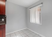 Thumbnail 33 of 38 - A kitchen with a white tile floor and a window with blinds.
